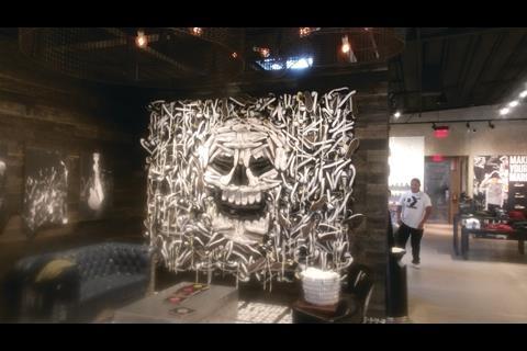 The store’s most arresting feature lies behind a screen, used to break up what is a big space. Here, a semi-3D image of a skull has been created, once more in black and white, using pairs of Converse sneakers.
